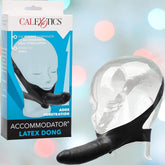 The product packaging showcases a transparent mannequin head adorned with a strap-on, prominently displaying the "CalExotics" brand and "The Original Accommodator Latex Dong Head Strap-on," emphasizing its attributes for oral pleasure. The backdrop glistens with multicolored bokeh lights, enhancing the captivating atmosphere.